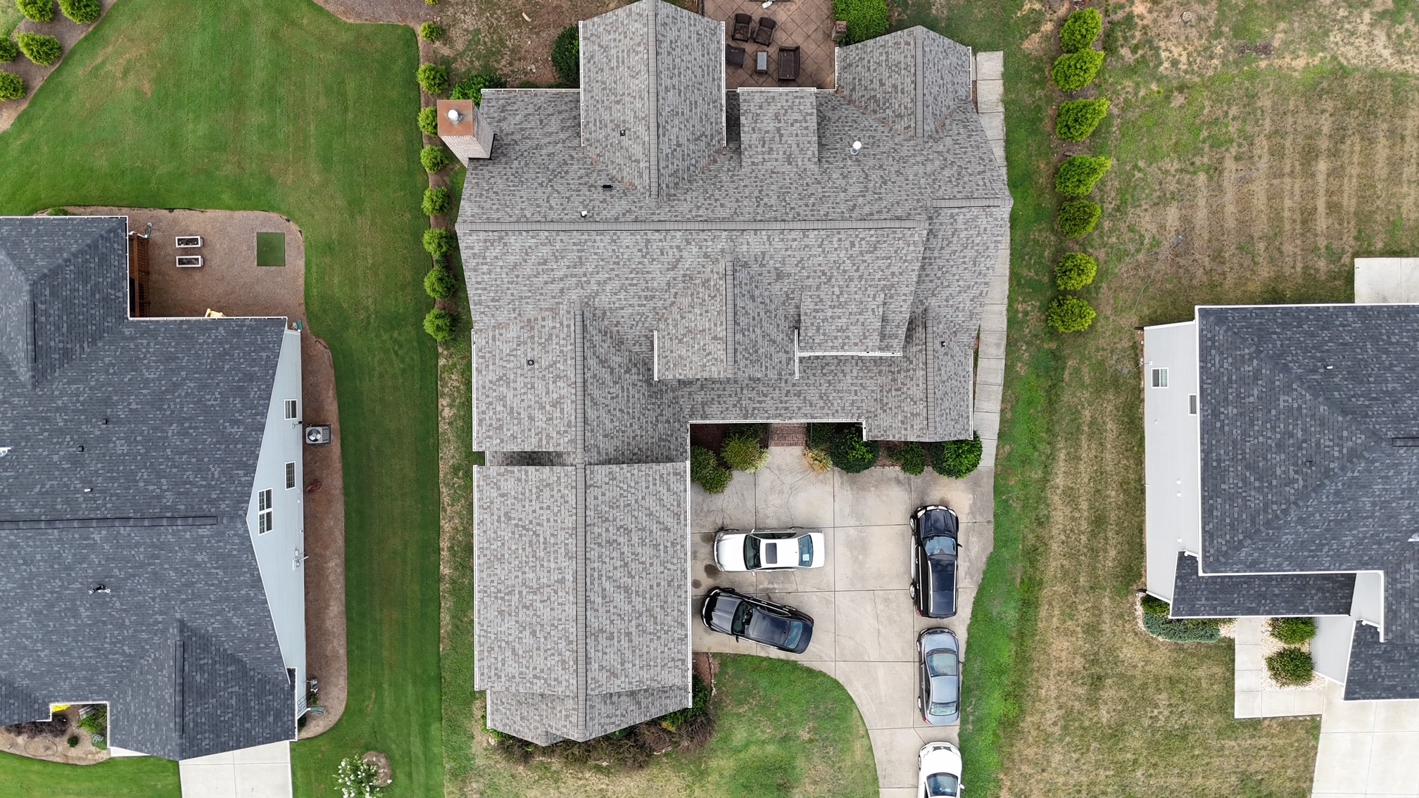 Aerial top-down view of a completed roof replacement on a large home in a Ballantyne, NC subdivision — installed by Charlotte Ace Roofing