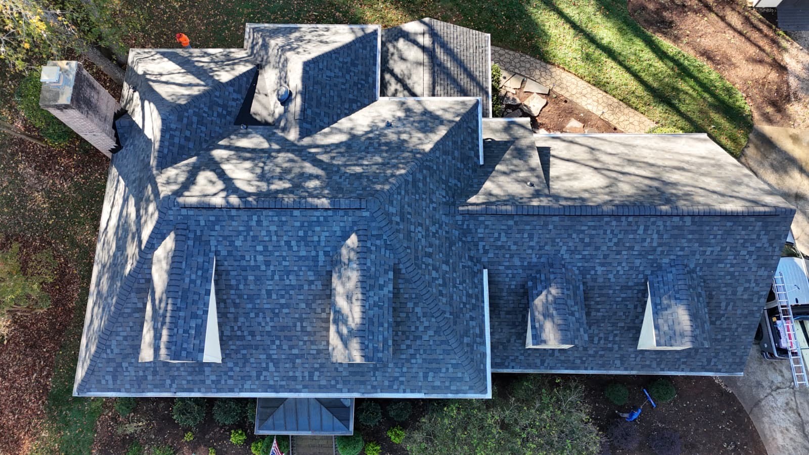 Aerial view of a completed architectural shingle roof replacement on a large brick home in Fort Mill, SC by Charlotte Ace Roofing