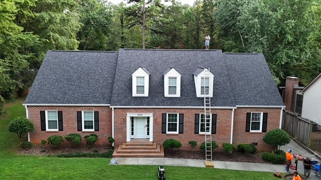 New asphalt shingle roof replacement on a Cape Cod brick home in Huntersville, NC — Charlotte Ace Roofing crew on site