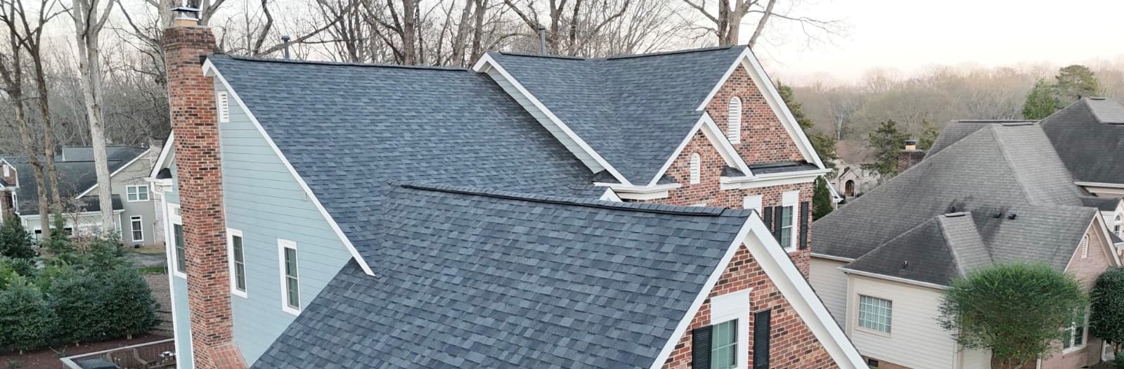 Completed dark-gray architectural shingle roof replacement on a traditional brick-and-Hardie home in SouthPark, Charlotte by Charlotte Ace Roofing