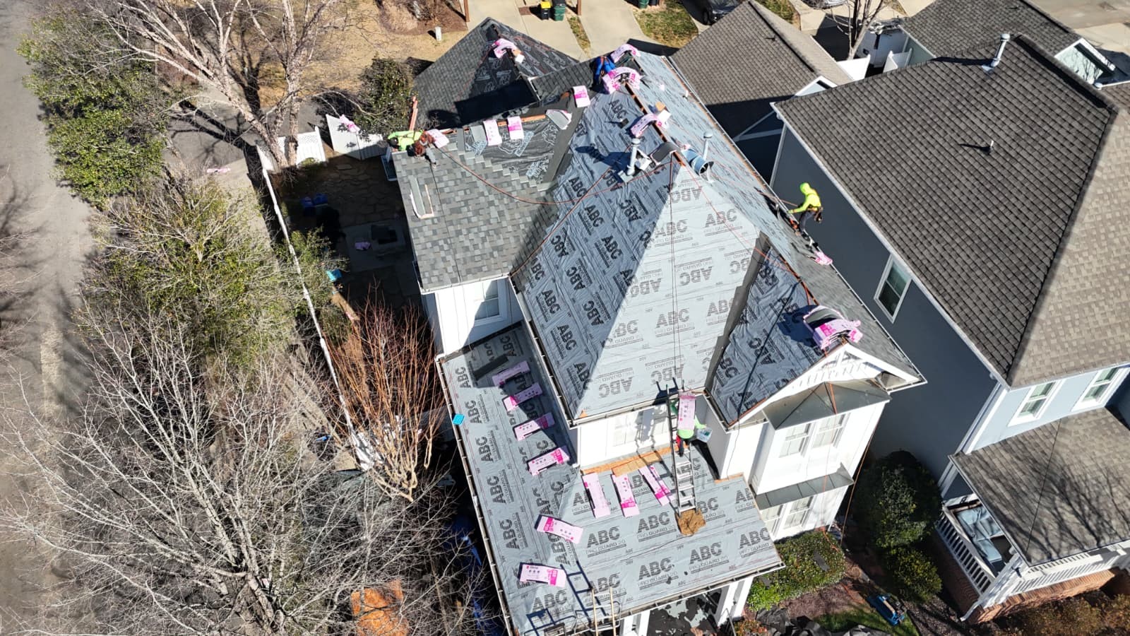 Aerial view of a roof installation in progress in the Weddington, NC area — ABC Guard underlayment with shingle bundles staged on a multi-peak roof