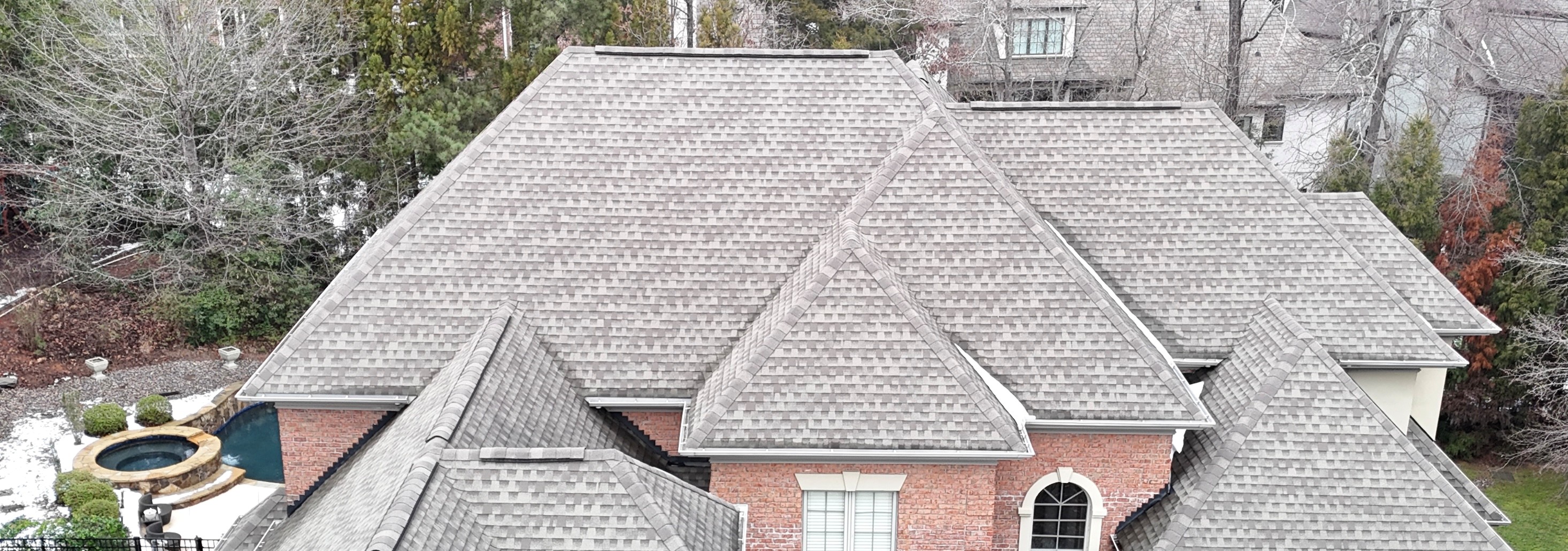 Aerial view of a completed luxury home with complex multi-peak architectural shingle roof in Weddington, NC — installed by Charlotte Ace Roofing